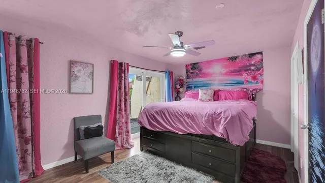 a bedroom with a bed a chandelier and pink walls