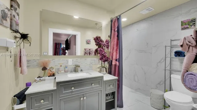 a bathroom with a sink vanity mirror and toilet
