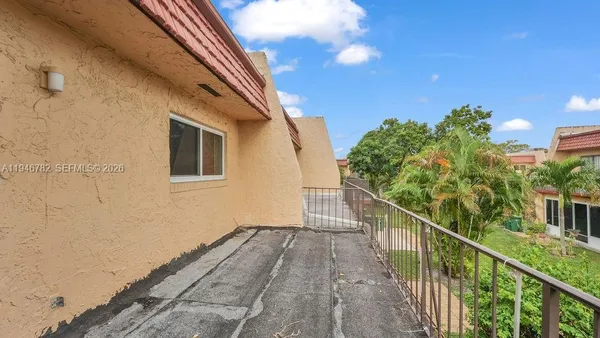 a view of a balcony with wooden floor and fence