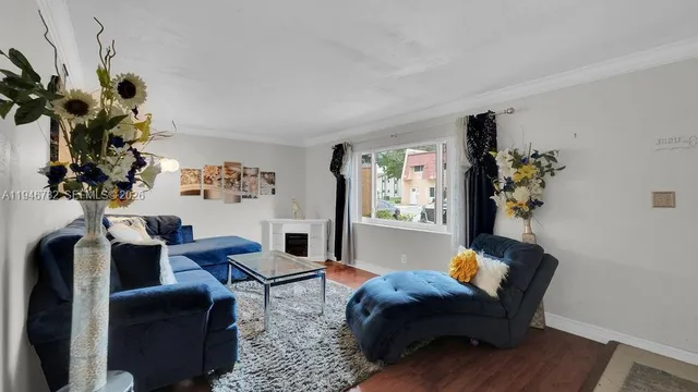 a living room with furniture flowerpot and a chandelier