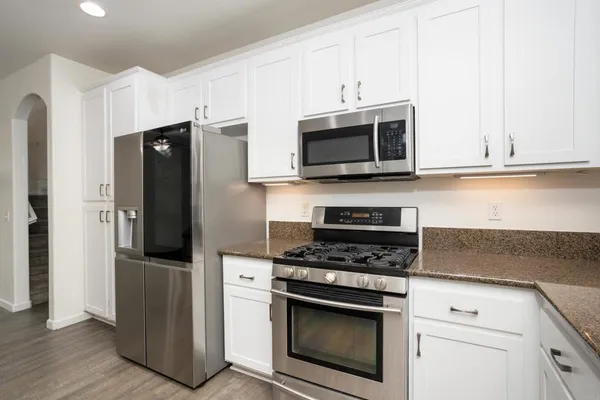 a kitchen with granite countertop white cabinets and a sink