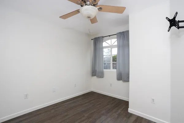 an empty room with a chandelier fan and a chandelier fan