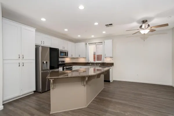 a kitchen with stainless steel appliances a stove top oven a sink and a refrigerator