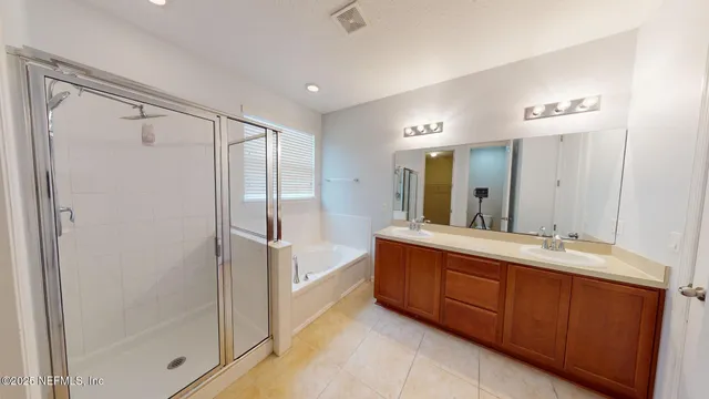 a bathroom with a double vanity sink mirror and shower