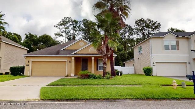 a front view of a house with a garden and plants