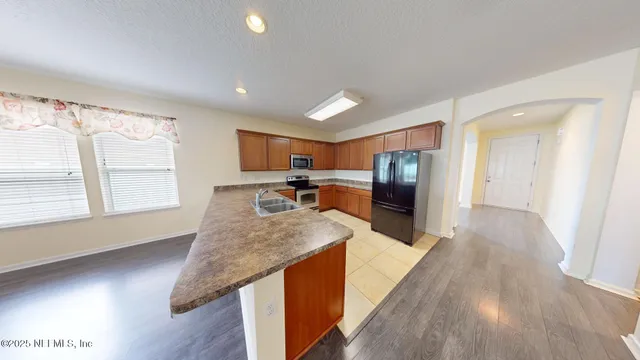 a view of a kitchen with a sink wooden floor and a living room