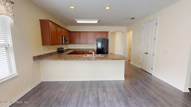 a view of kitchen with wooden floor and electronic appliances