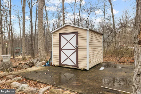 a backyard of a house with large trees and outdoor seating