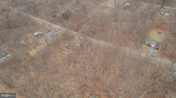 a view of a dry yard with brick wall and covered with snow