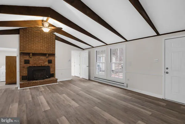 a view of empty room with kitchen and fireplace