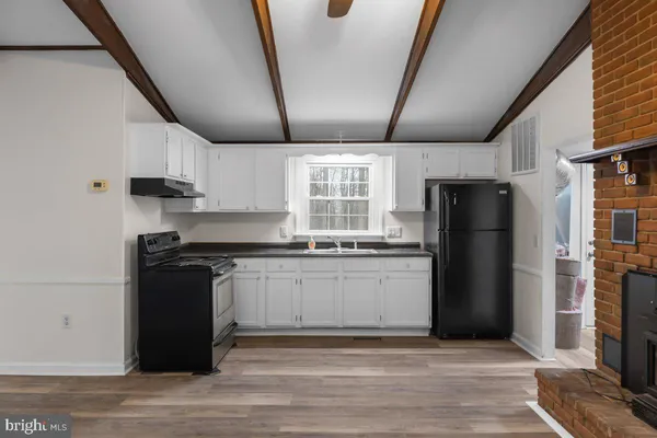 a kitchen with granite countertop a stove and cabinets