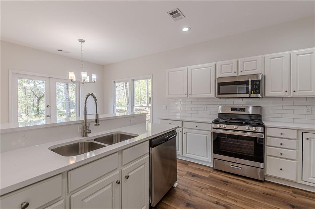 775 Southland Pass Stone Mountain, GA 30087 - Photo 19 of 76 a kitchen with sink a microwave and cabinets