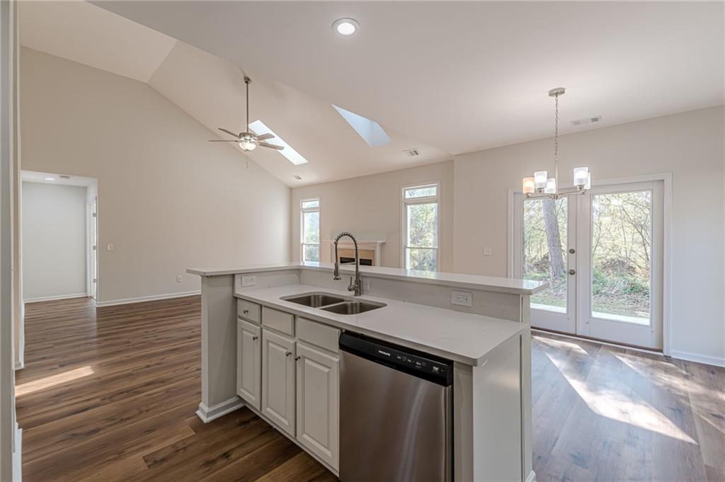 775 Southland Pass Stone Mountain, GA 30087 - Photo 22 of 76 a kitchen with a sink chandelier and wooden floor