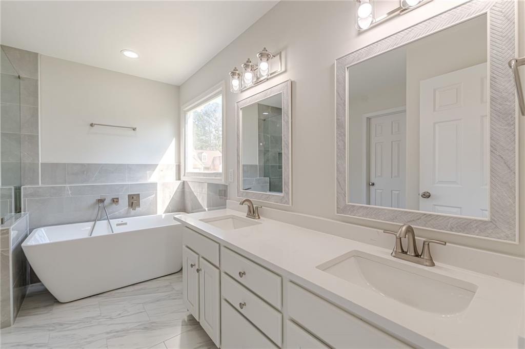 775 Southland Pass Stone Mountain, GA 30087 - Photo 32 of 76 a bathroom with 2 sink tub and a mirror