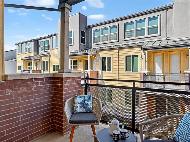 a white wall with a white comforter and a painting on it