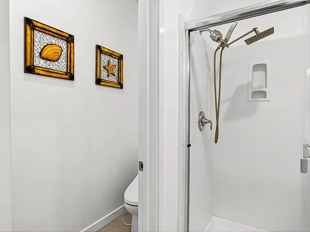 a room with a ceiling fan and a shower