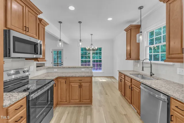a kitchen with a sink stove top oven and refrigerator