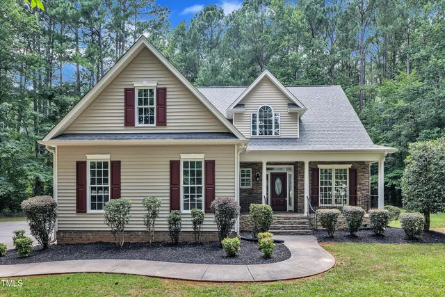 a front view of a house with a yard and potted plants