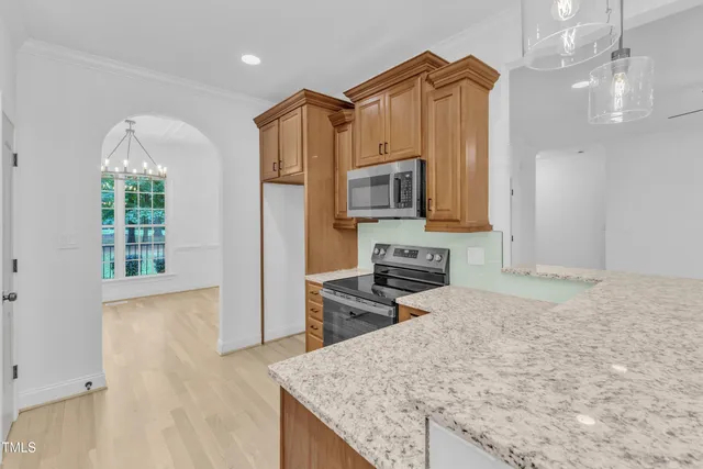 a kitchen with stainless steel appliances granite countertop a stove a sink and a microwave