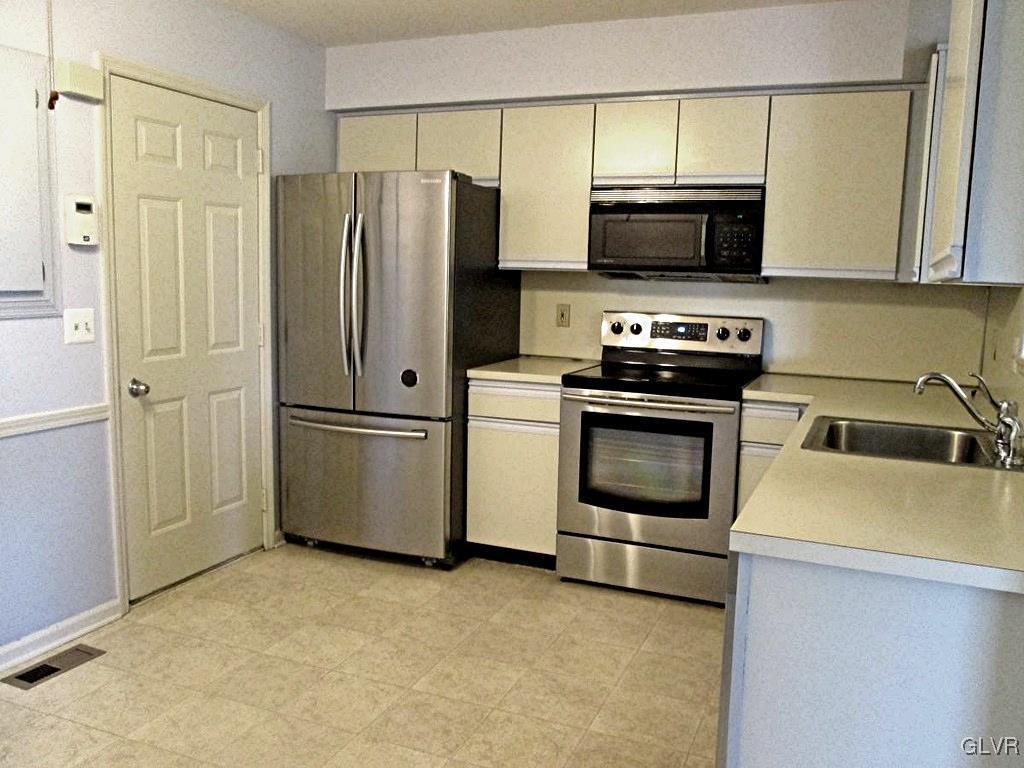 1201 Butztown Road, Unit 22 Bethlehem, PA 18017 - Photo 13 of 23 a kitchen with stainless steel appliances a refrigerator stove and microwave