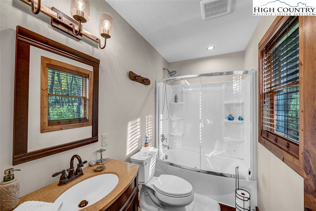 428 Cloud Spring Drive Sugar Mountain, NC 28604 - Photo 15 of 45 a bathroom with a sink toilet a mirror and shower
