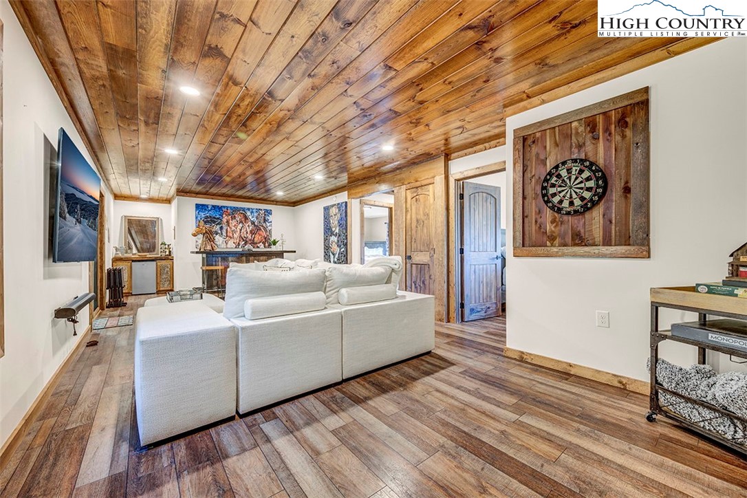 428 Cloud Spring Drive Sugar Mountain, NC 28604 - Photo 7 of 45 a living room with furniture a flat screen tv and a wooden floor
