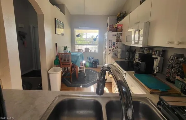 a kitchen with stainless steel appliances a sink a stove top oven a counter space and cabinets