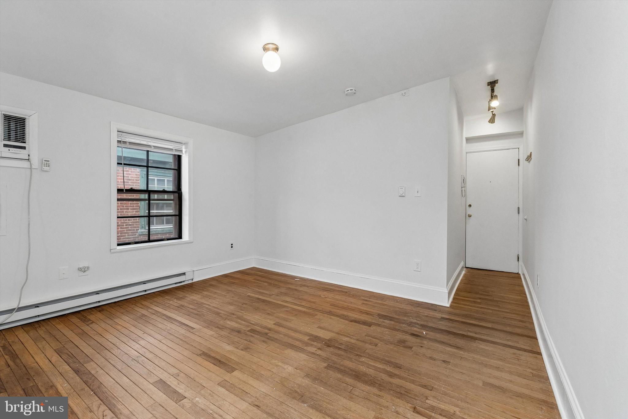 2105 Green Street, Unit 3R Philadelphia, PA 19130 - Photo 6 of 11 an empty room with wooden floor cabinet and windows