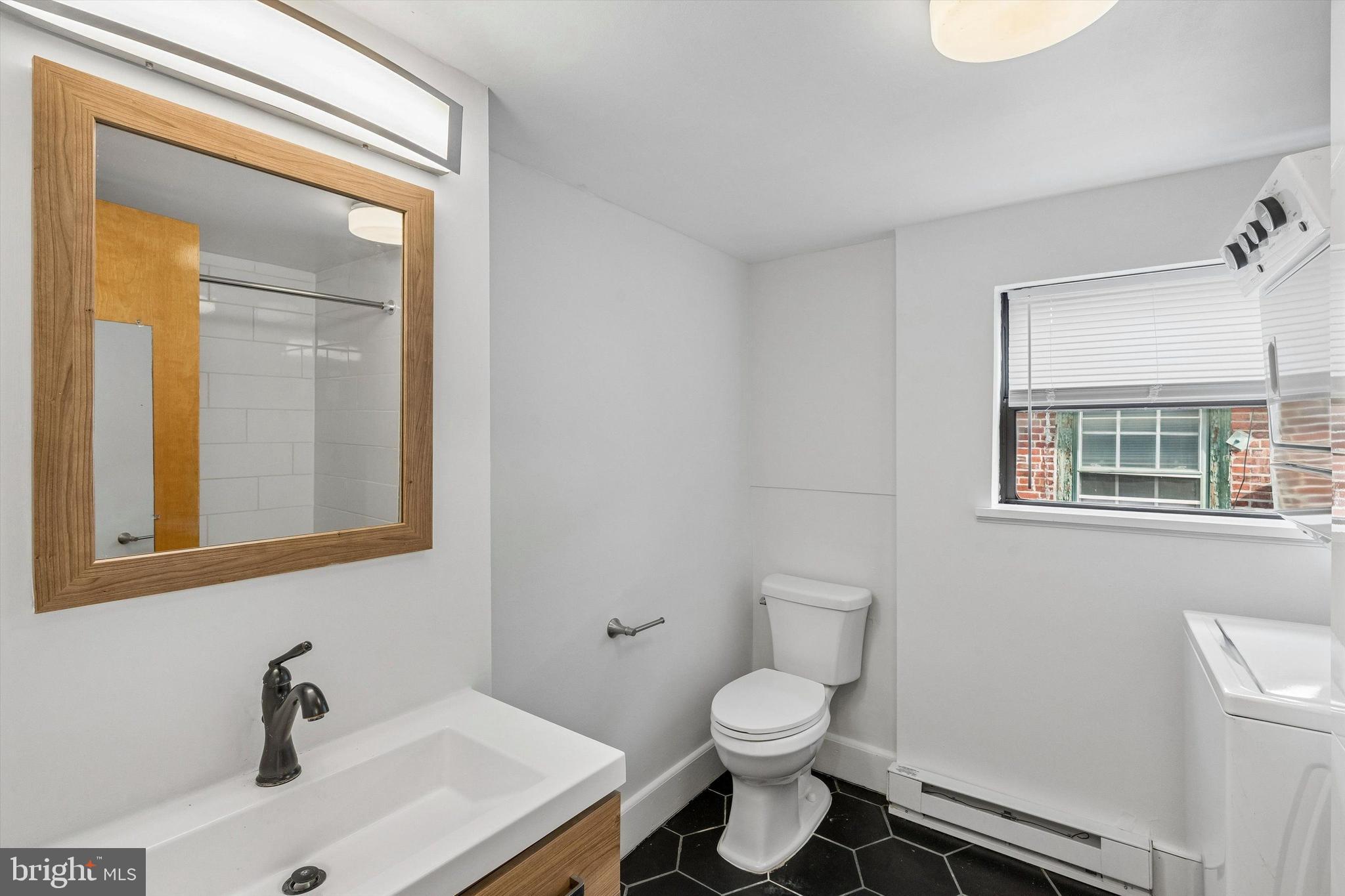 2105 Green Street, Unit 3R Philadelphia, PA 19130 - Photo 7 of 11 a bathroom with a sink a toilet and mirror