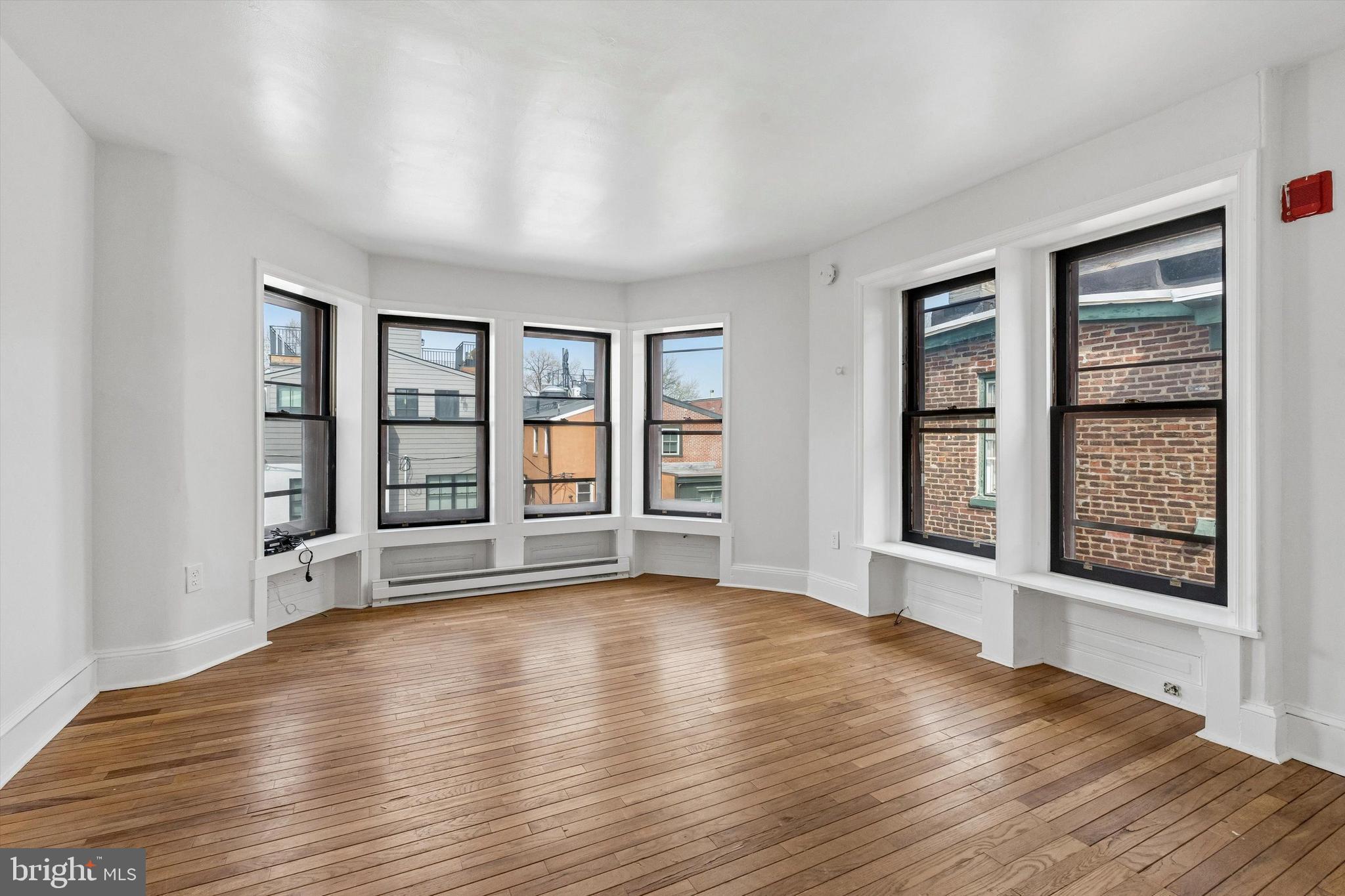 2105 Green Street, Unit 3R Philadelphia, PA 19130 - Photo 8 of 11 a view of an empty room with wooden floor and a window