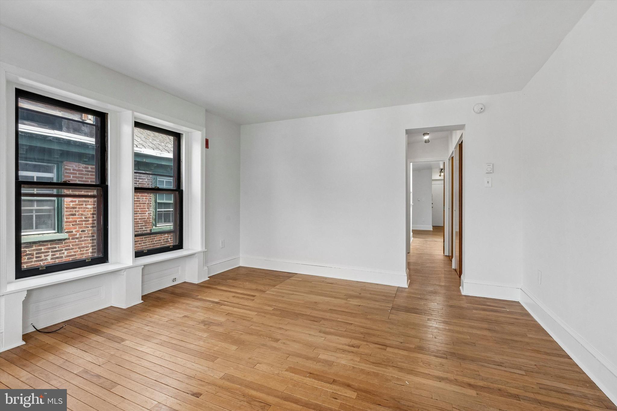 2105 Green Street, Unit 3R Philadelphia, PA 19130 - Photo 10 of 11 a view of an empty room with wooden floor and a window