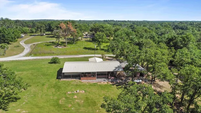 a front view of house with yard and trees in the background