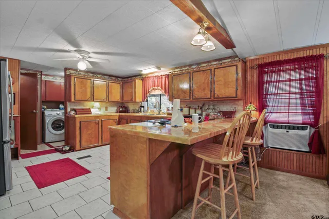 a kitchen with stainless steel appliances kitchen island granite countertop a dining table chairs sink and window
