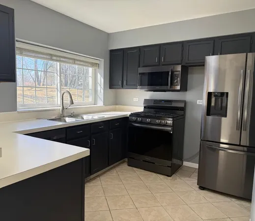 a kitchen with granite countertop a refrigerator and a sink