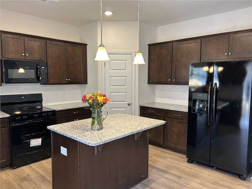 23 Whistling Oaks NE Drive Rome, GA 30165 - Photo 7 of 26 a kitchen with stainless steel appliances granite countertop a refrigerator a stove and a sink with wooden cabinets