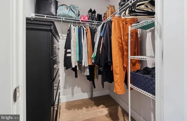 a view of walk in closet with clothes and shoes
