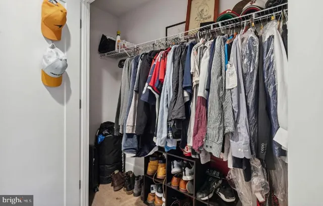 a view of walk in closet with clothes and shoes