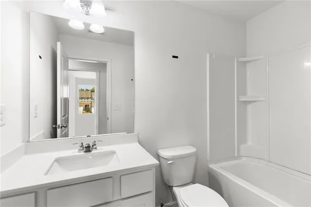 a bathroom with a sink vanity mirror and toilet