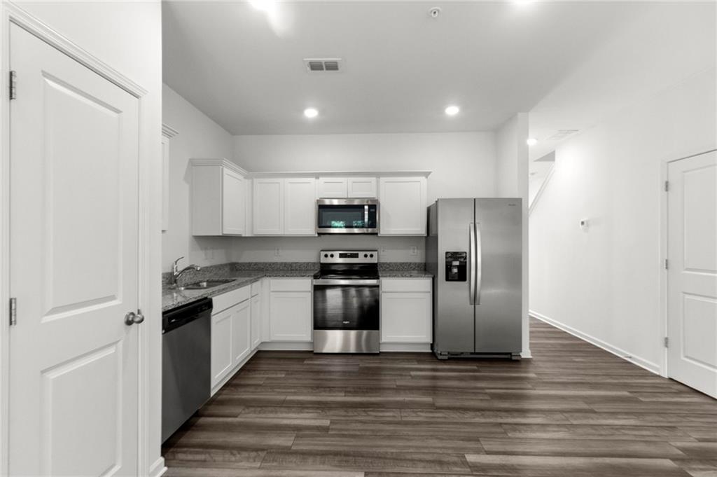 509 Magnolia Circle Palmetto, GA 30268 - Photo 6 of 24 a kitchen with stainless steel appliances granite countertop a refrigerator and a stove top oven