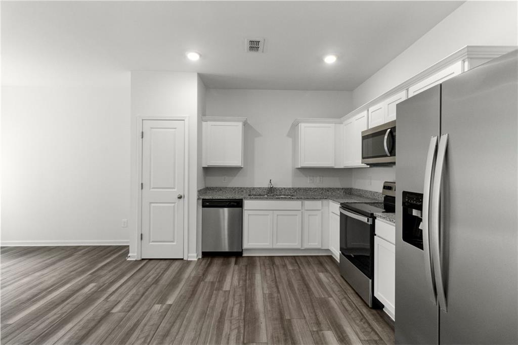 509 Magnolia Circle Palmetto, GA 30268 - Photo 8 of 24 a kitchen with granite countertop stainless steel appliances a sink and refrigerator