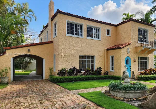 a front view of a house with a garden and plants
