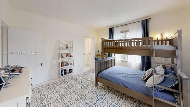 a bed sitting in a bedroom next to a window