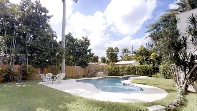 a view of a house with backyard and sitting area
