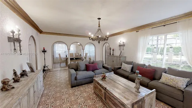 a living room with furniture a chandelier and a large window