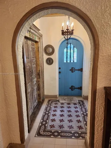 a living room with furniture a chandelier and a fireplace