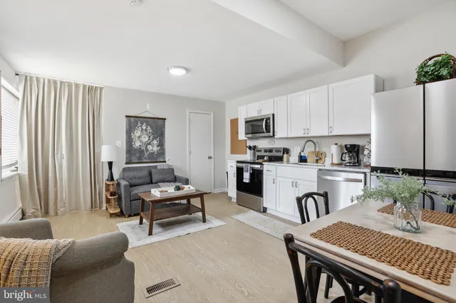 a kitchen with sink refrigerator dining table and chairs