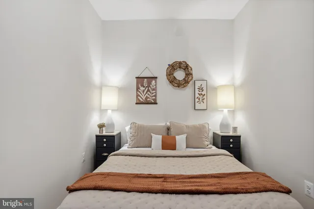 a bedroom with a bed and painting on the wall