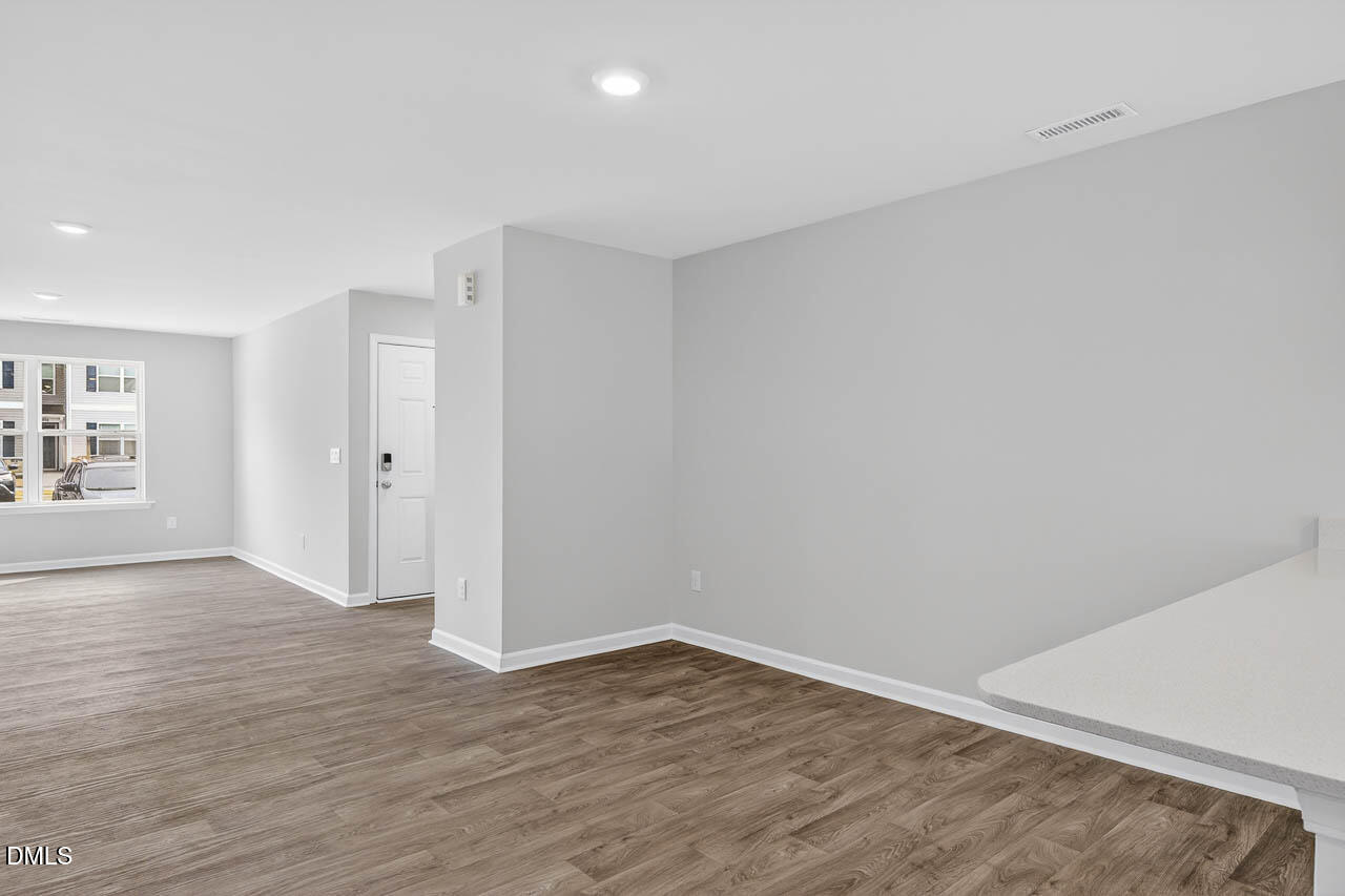 8535 Beckett Chase Way Raleigh, NC 27616 - Photo 11 of 33 a view of an empty room with wooden floor and a window