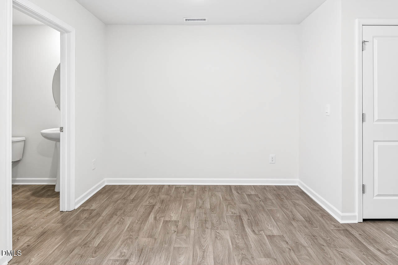 8535 Beckett Chase Way Raleigh, NC 27616 - Photo 13 of 33 a view of a room with wooden floor and a toilet