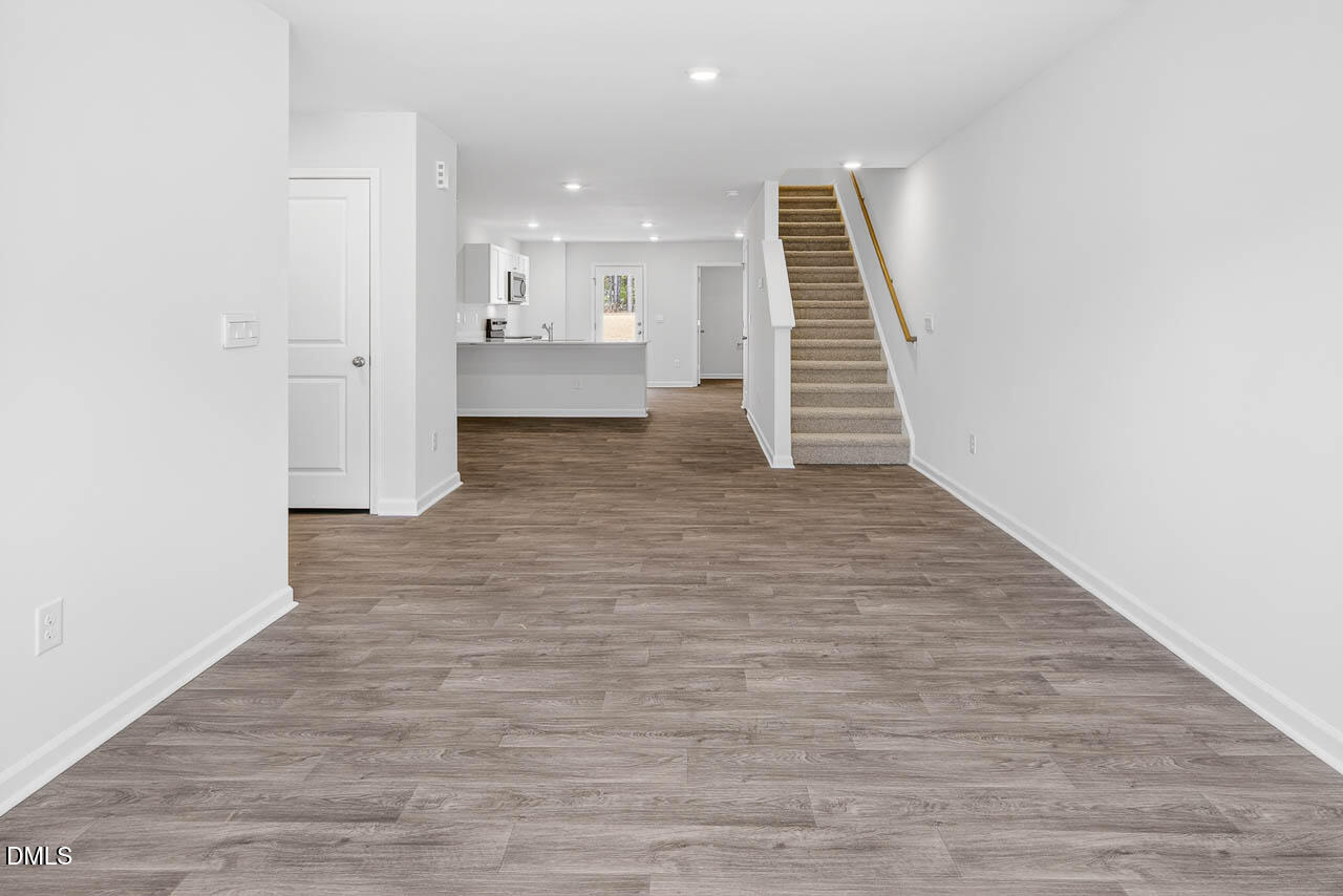 8535 Beckett Chase Way Raleigh, NC 27616 - Photo 18 of 33 a view of a hallway with stairs and wooden floor